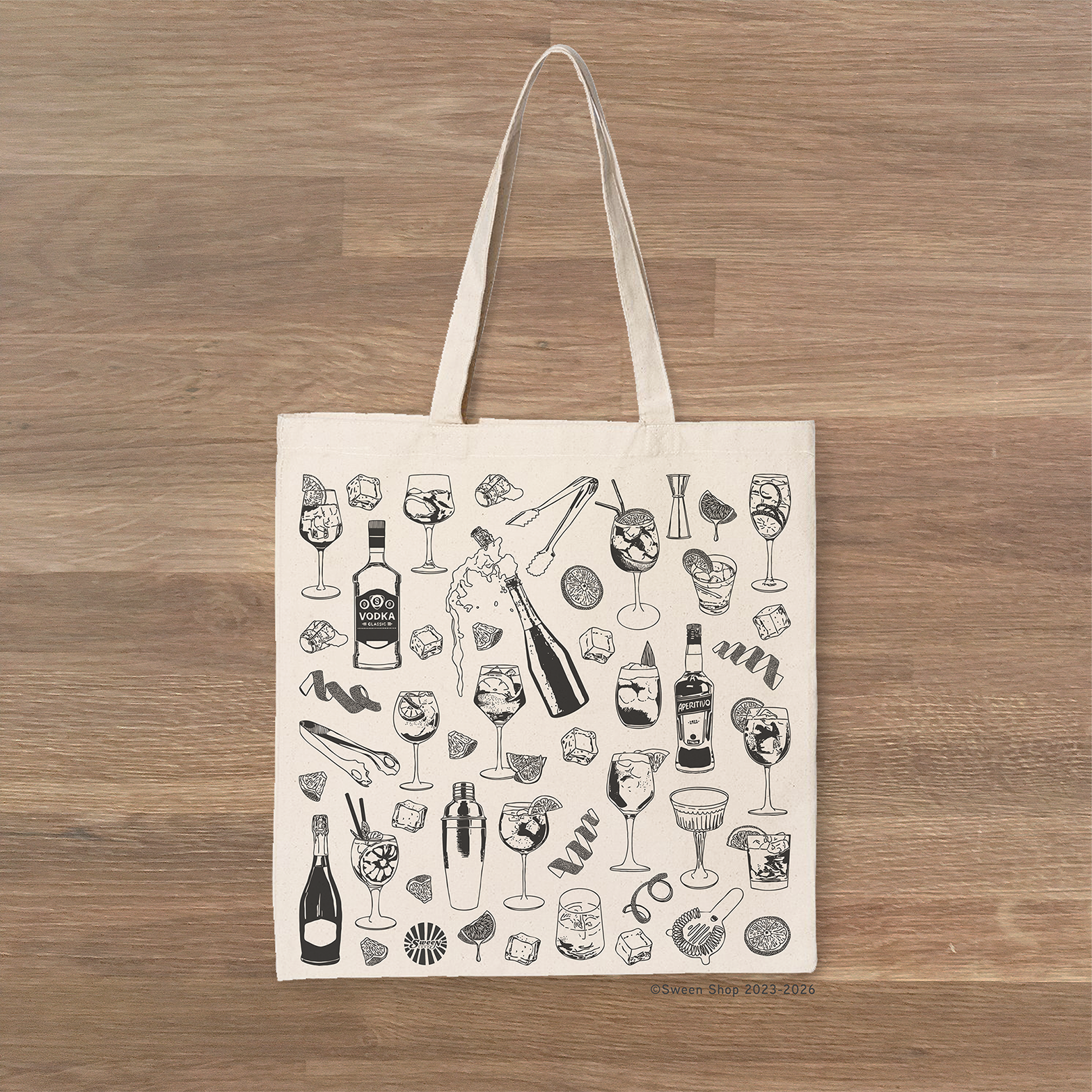 Tote bag with black Aperol Spritz Cocktail drink-themed hand drawn illustration print on a wooden surface