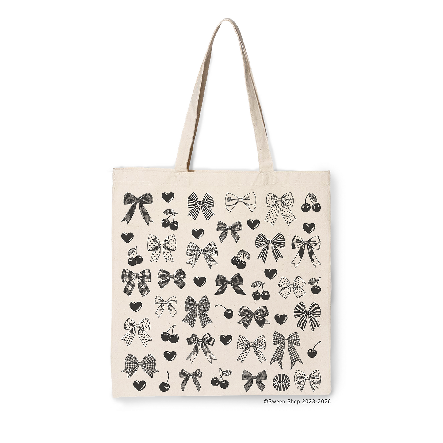 Natural cotton canvas tote bag with black bow, cherry, and heart hand drawn printed pattern on a white background