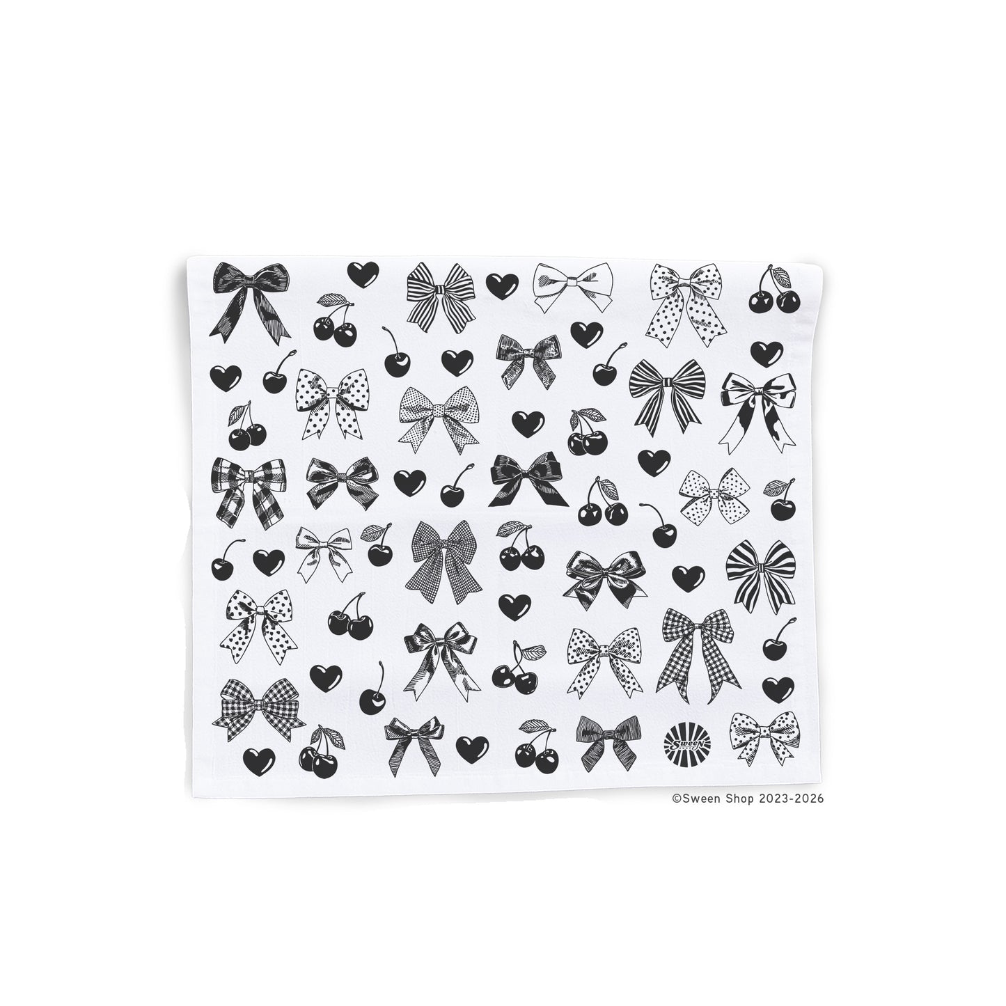 cotton kitchen towel of black line drawings of bows, hearts, and cherries on a white background