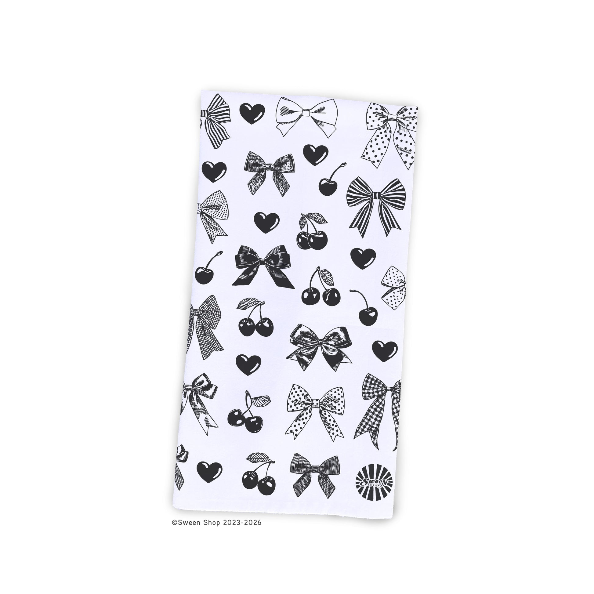 white cotton kitchen towel with drawing of bows, hearts, and cherries on a white background.
