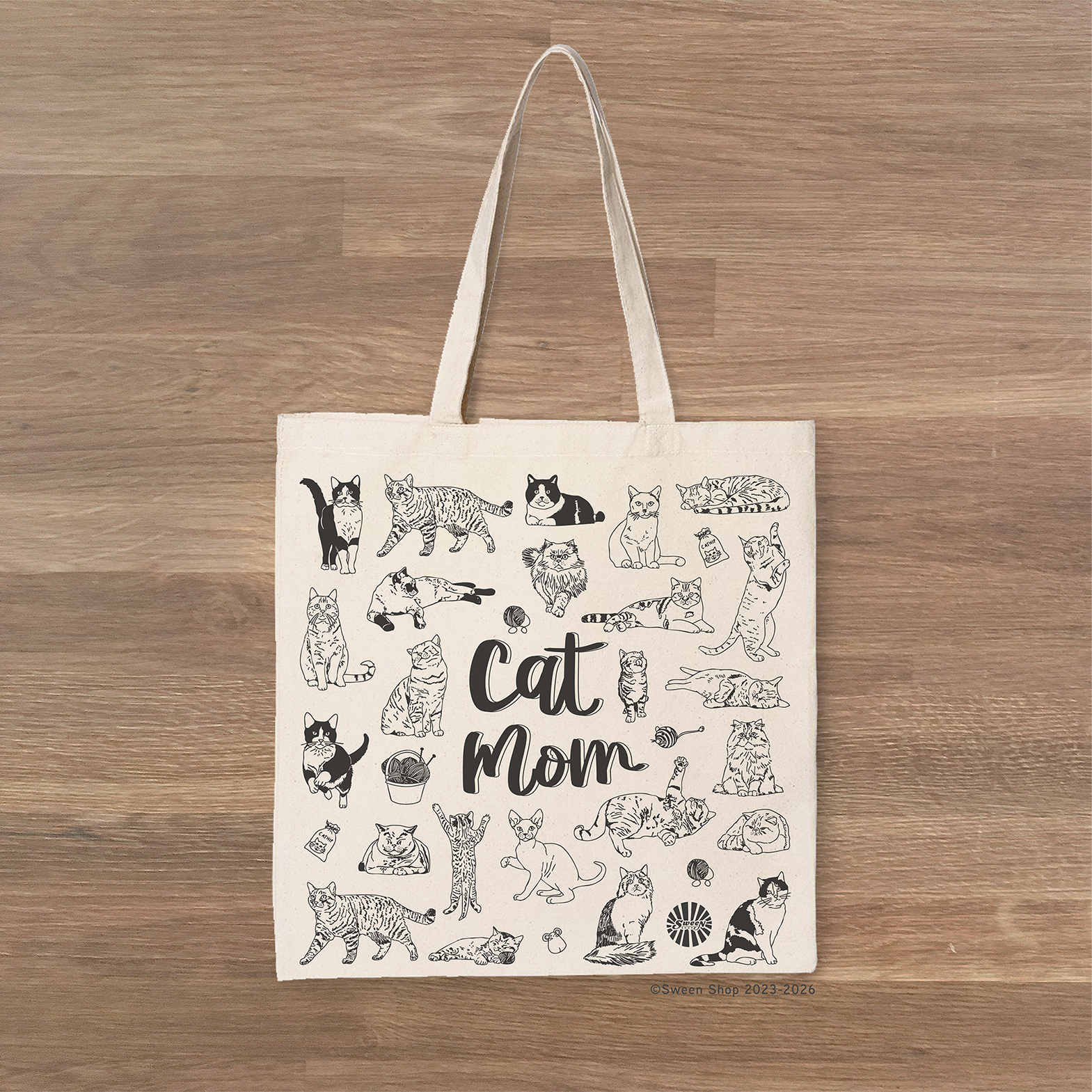 Tote bag with 'Cat Mom' design on a wooden surface