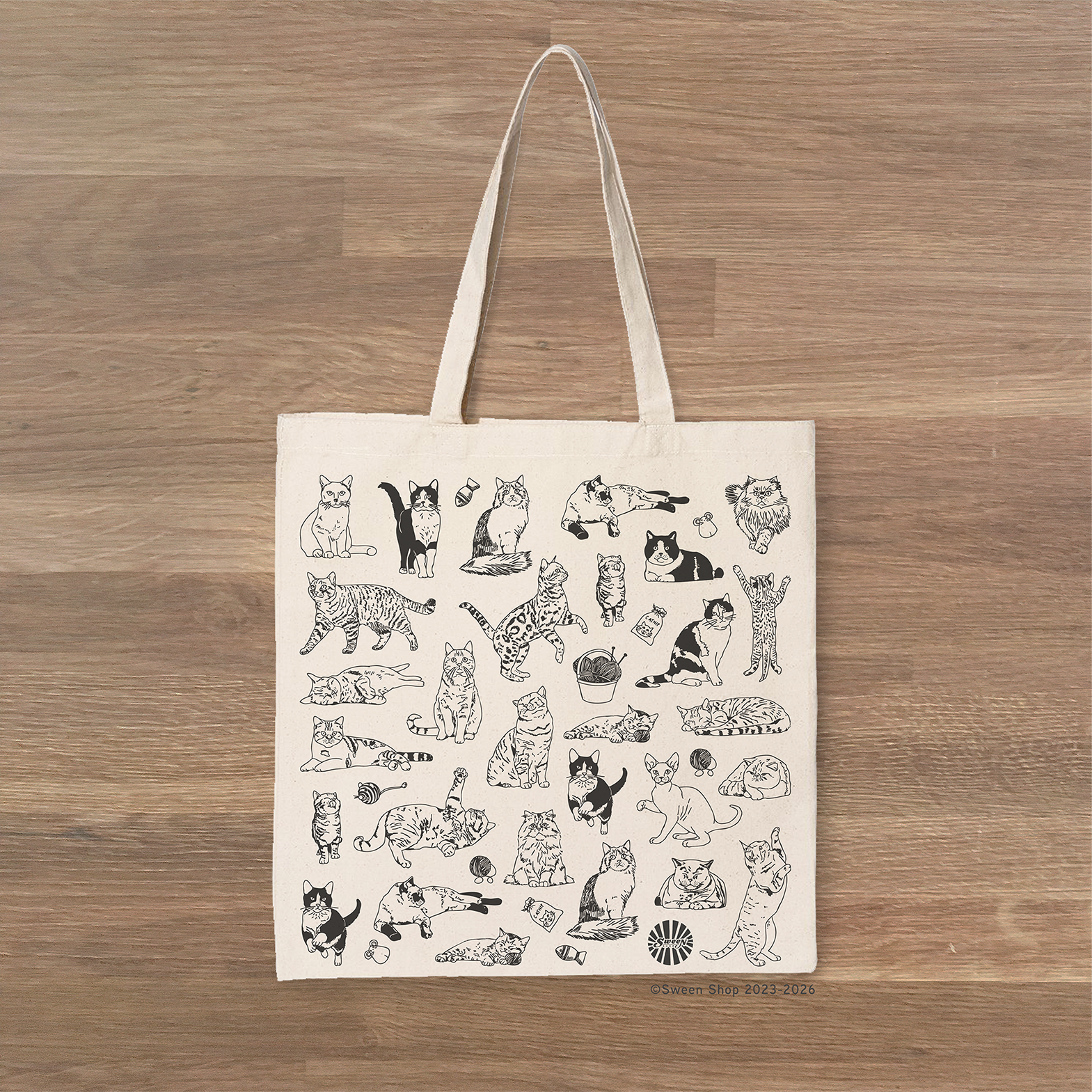 Tote bag with black pet cat animal illustrations on a wooden surface