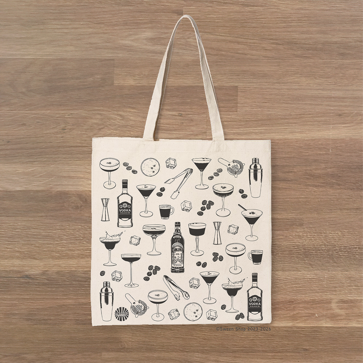 Tote bag with espresso martini cocktail-themed design on a wooden surface