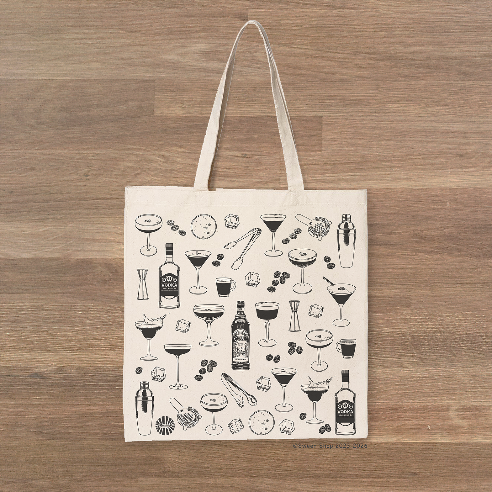 Tote bag with espresso martini cocktail-themed design on a wooden surface