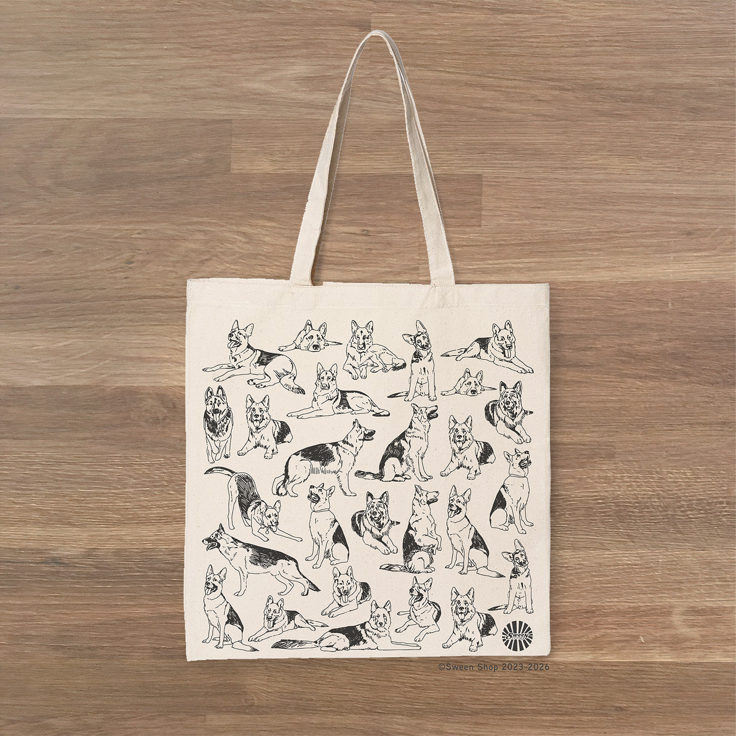 Tote bag with german shepherd pet dog illustrations on a wooden surface