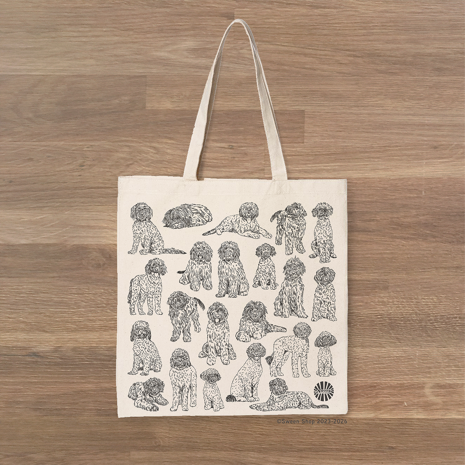 Tote bag with golden doodle pet dog illustrations on a wooden surface