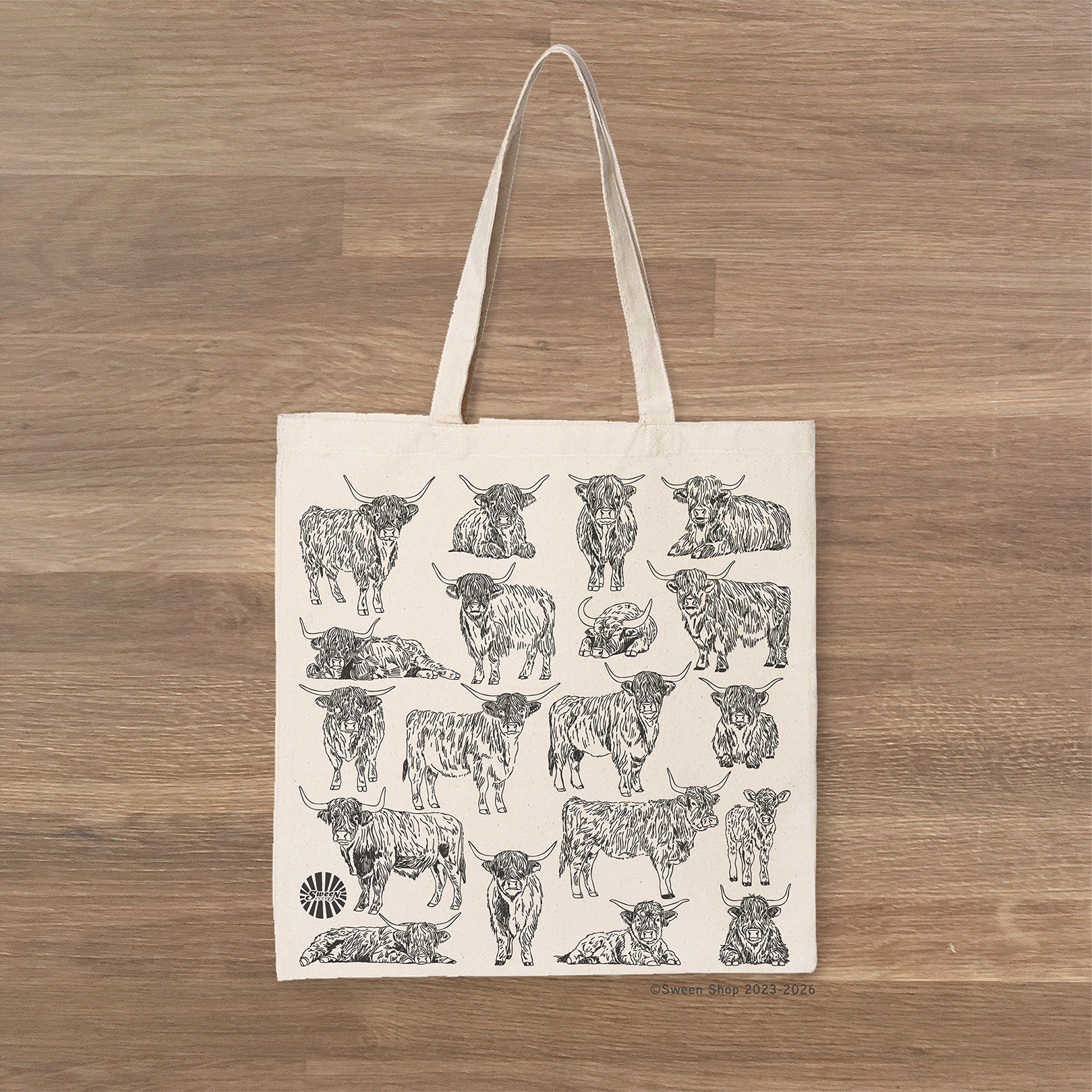 Tote bag with highlnad cow pattern on a wooden surface