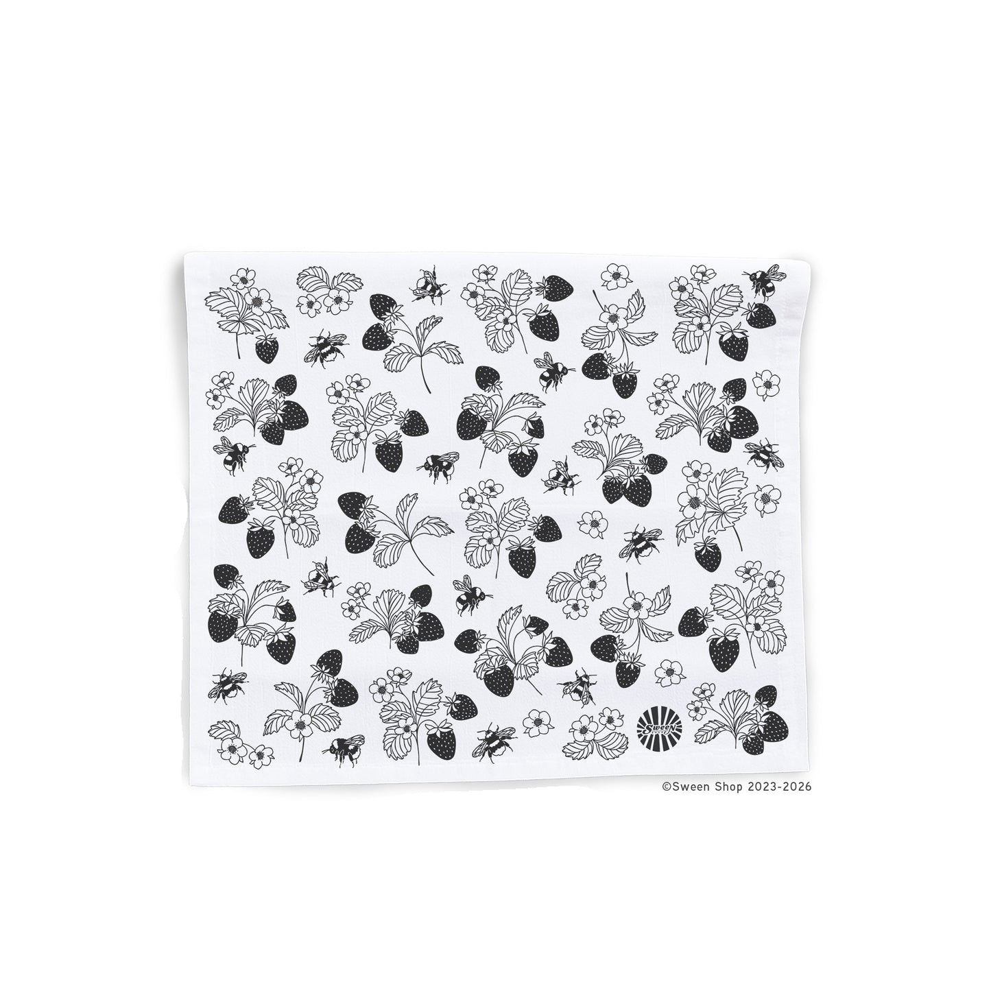 White kitchen towel with black floral strawberry and bumble bee pattern on a white background