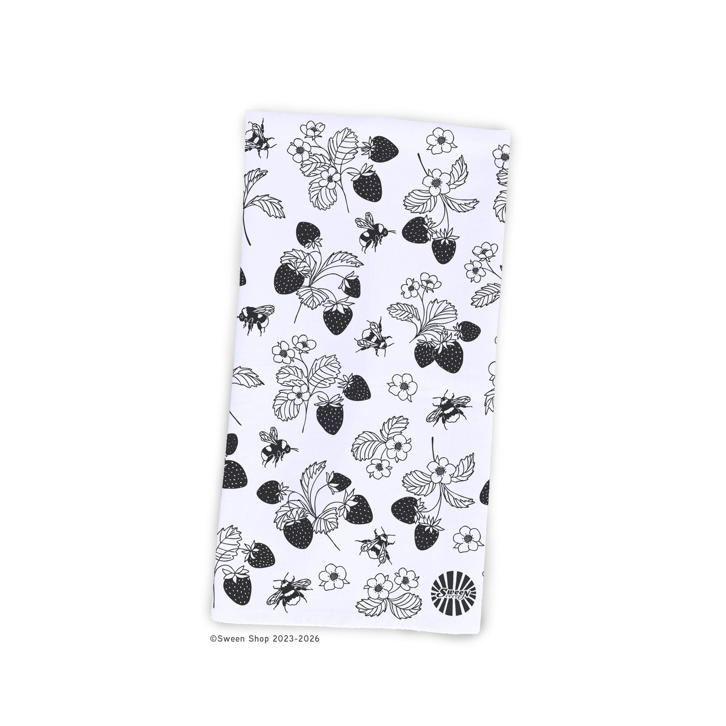 White kitchen towel with black strawberry and bee pattern on a white background