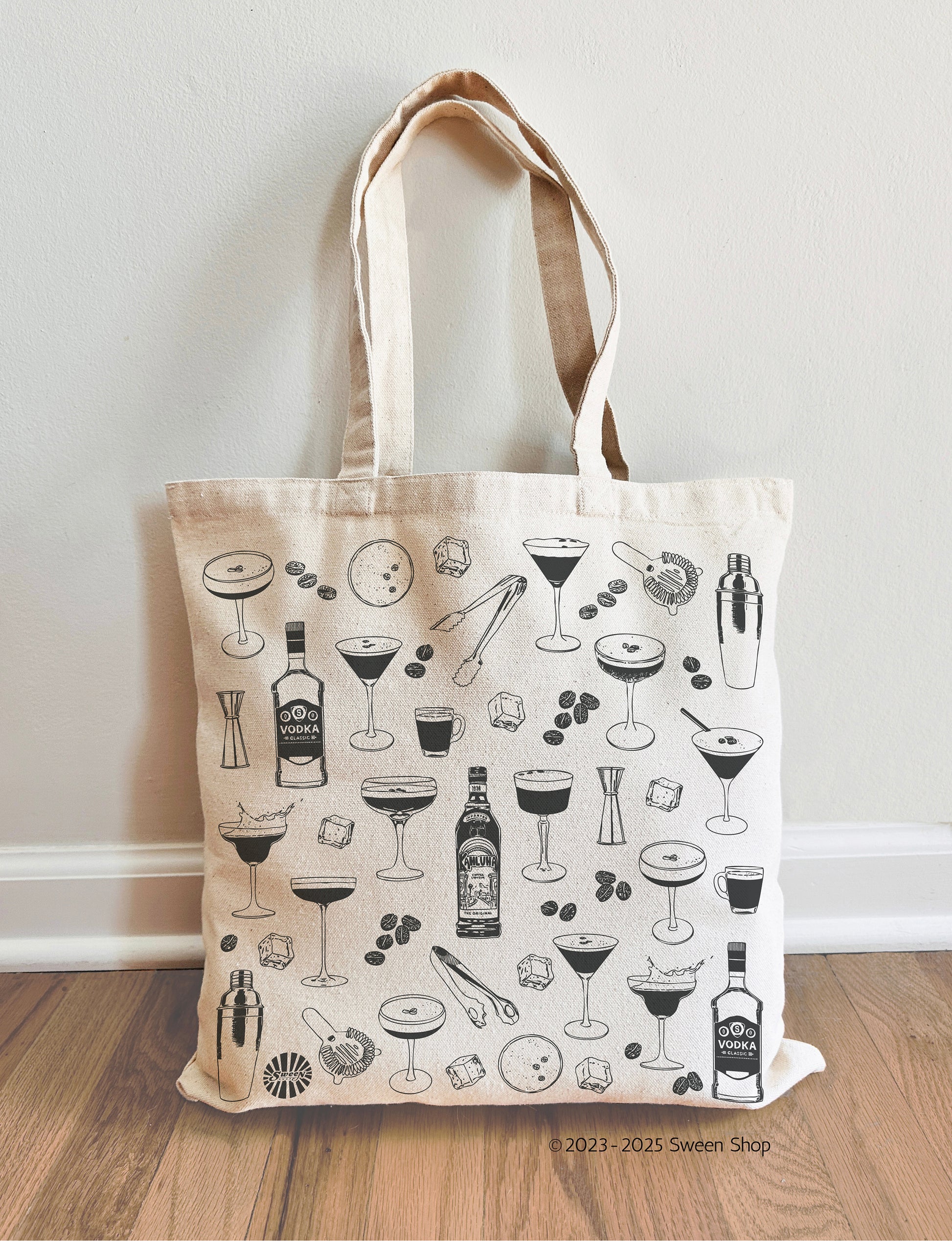 Tote bag with espresso martini cocktail-themed design on a wooden floor