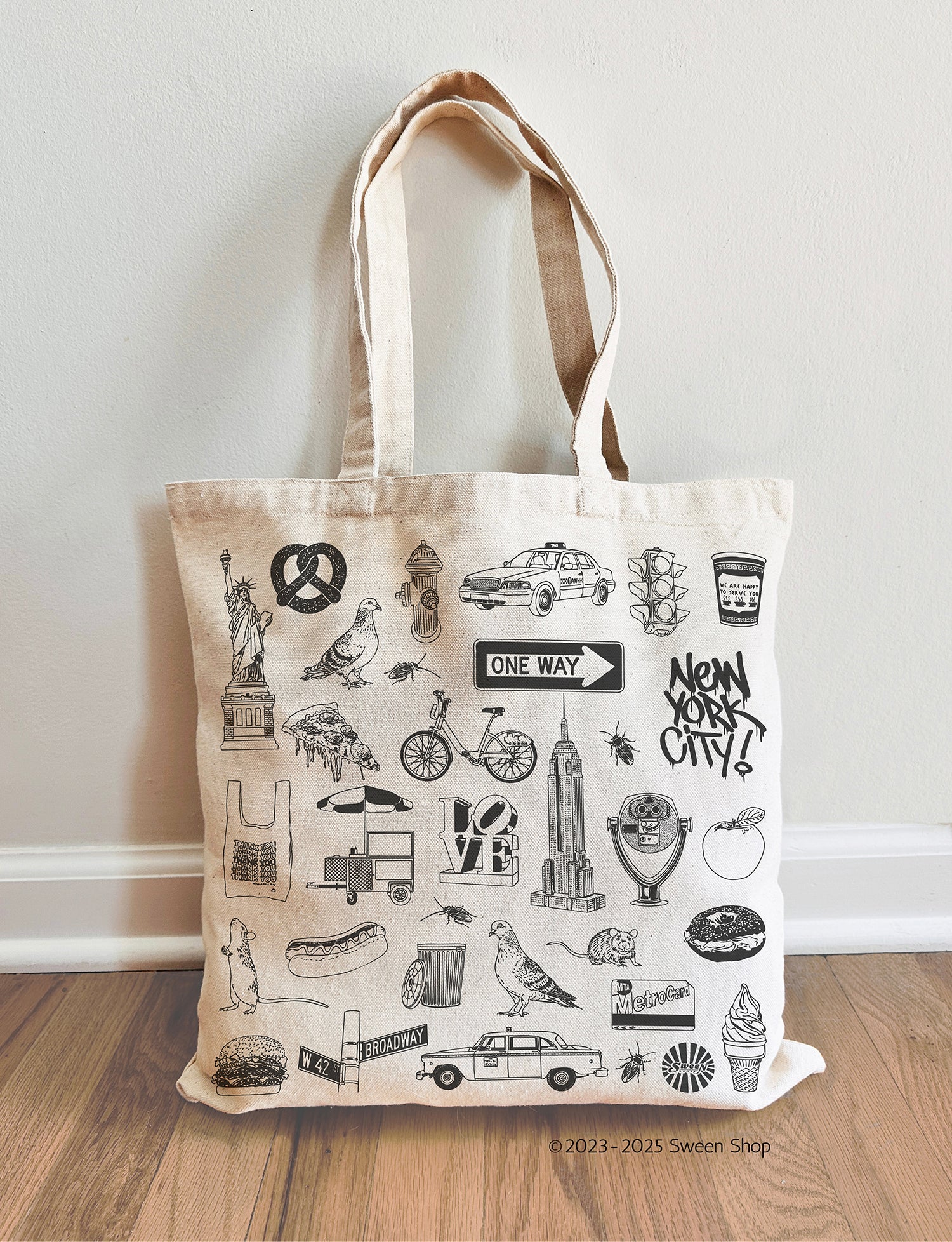 natural cotton canvas Tote bag with New York City-themed illustrations on a wooden floor.